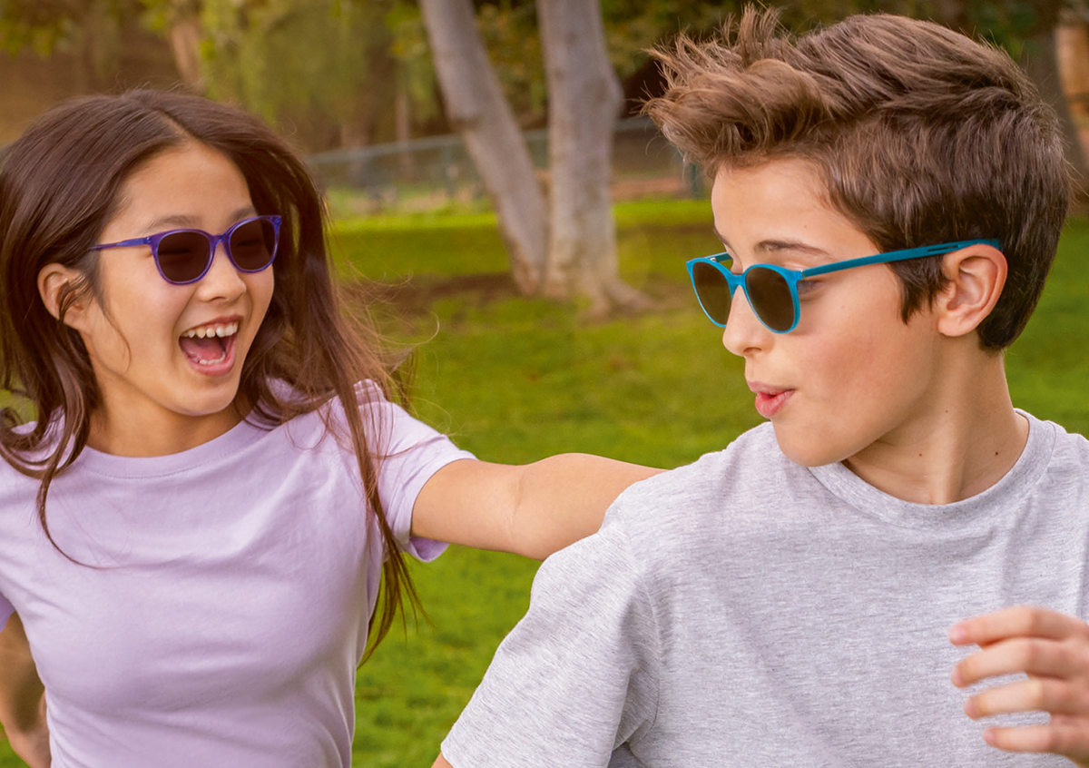 Mädchen und Junge in der Natur tragen Sonnenbrille